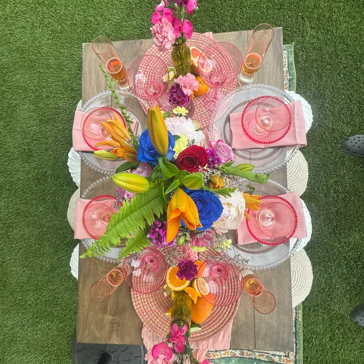 Vibrant tablescape with pink glassware and tropical florals